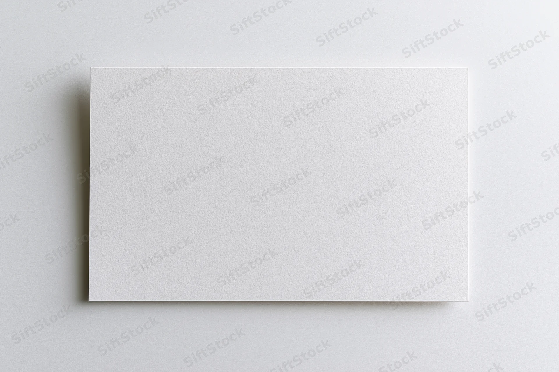 Blank white rectangular card lying flat on a neutral surface