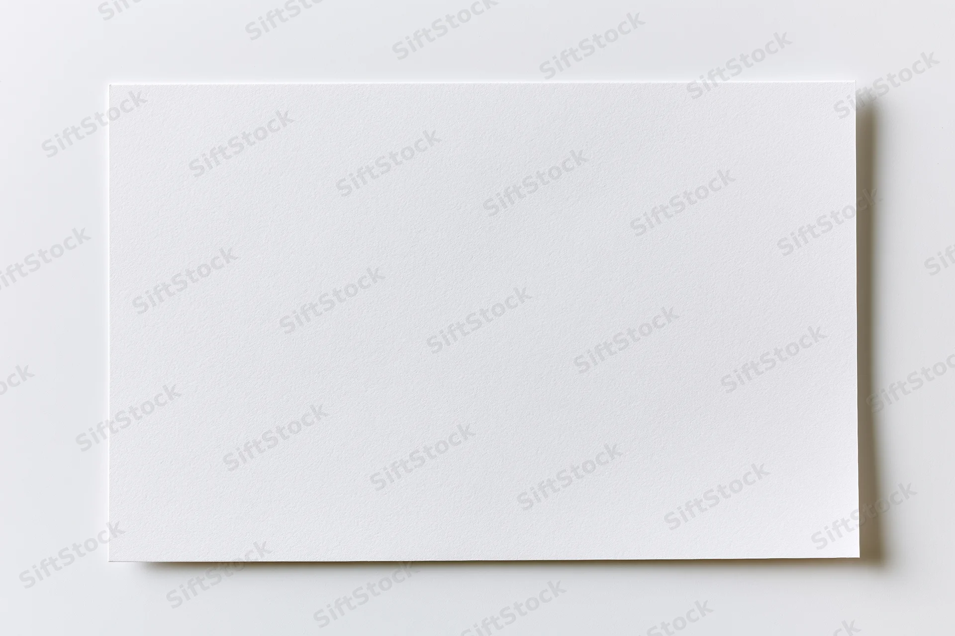 Blank white rectangular card lying flat on a light surface