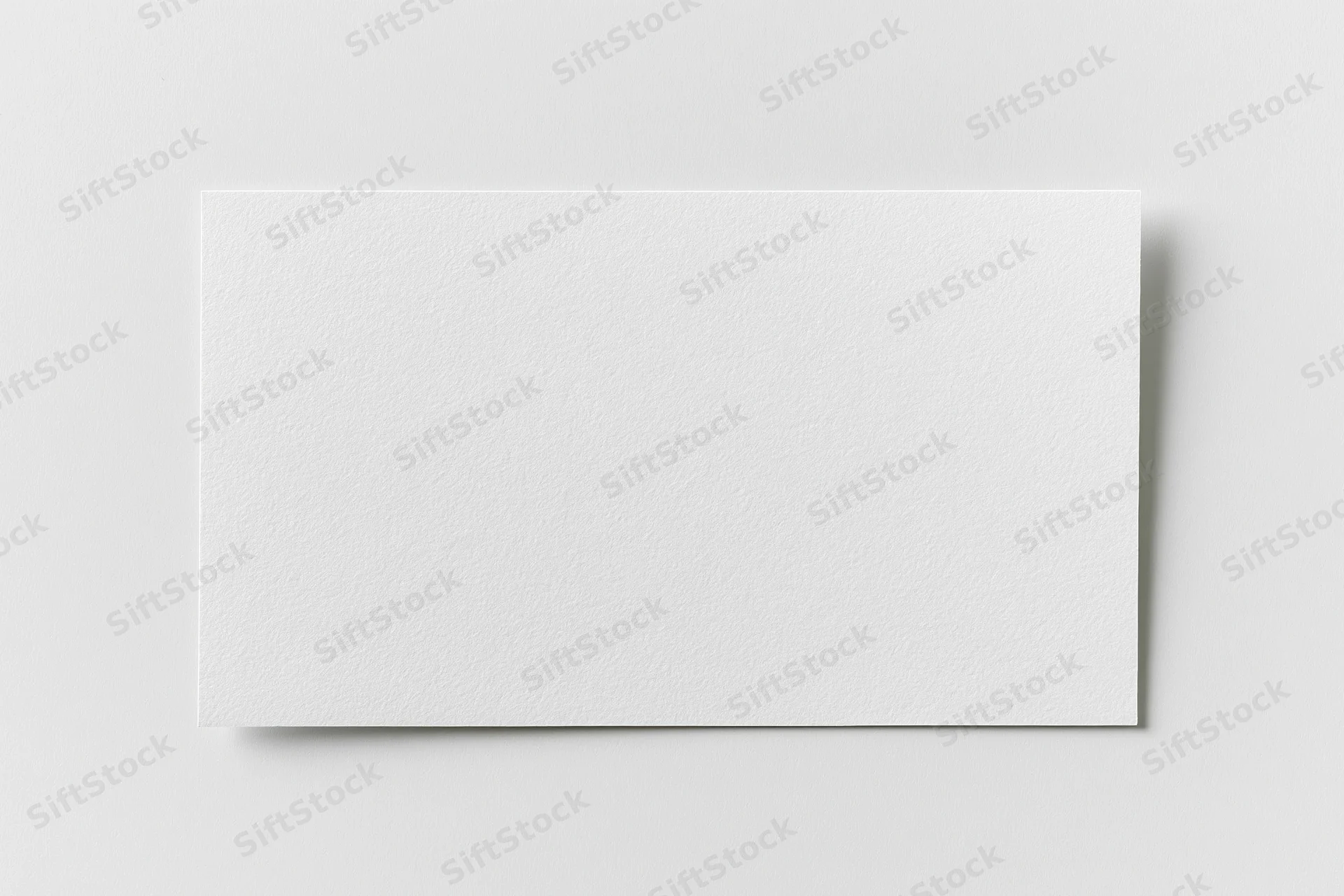 Blank white rectangular card lying flat on a plain surface