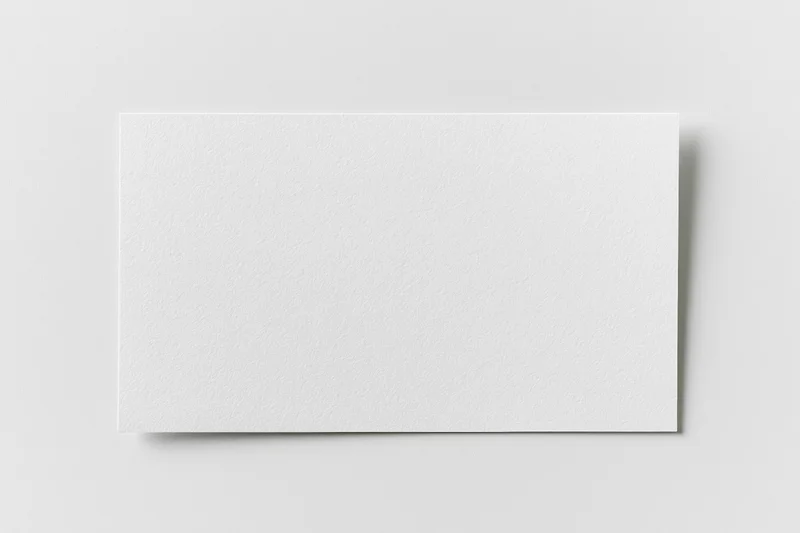 Blank white rectangular card lying flat on a plain surface