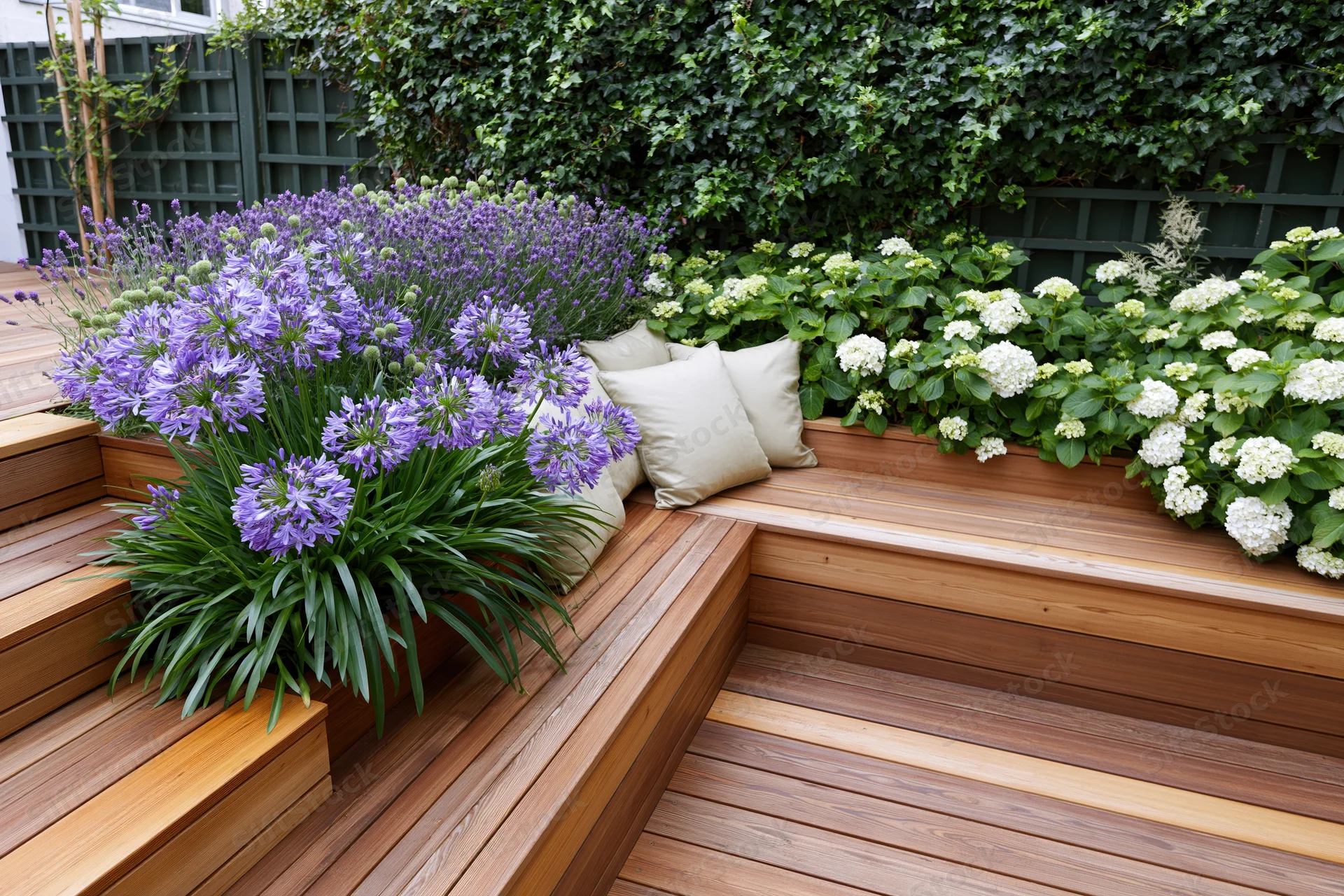 Built-in hardwood bench with purple and white flowers in a compact urban garden terrace