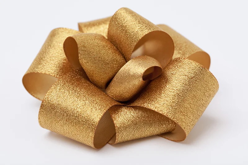 Gold satin ribbon bow with multiple loops on white background
