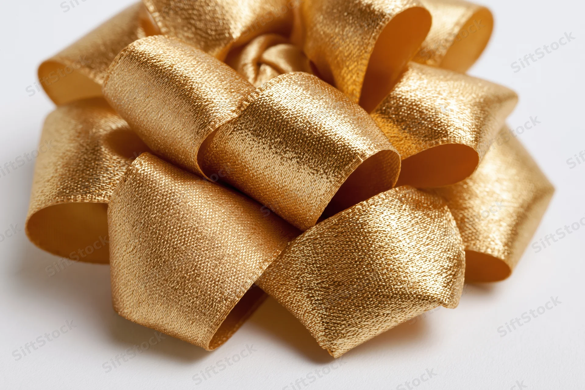 Gold satin ribbon bow with multiple loops on white background