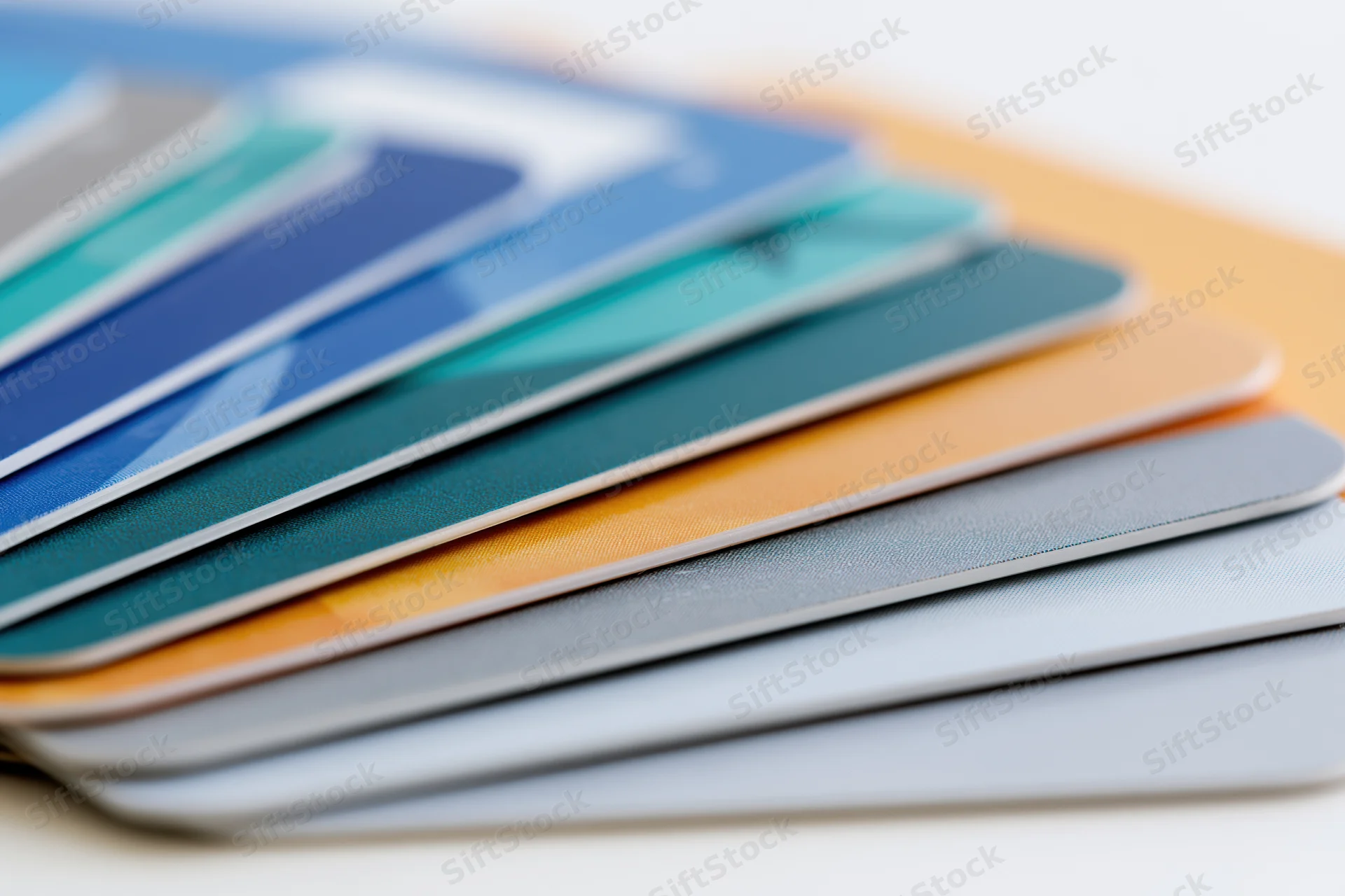 Fanned stack of colorful plastic credit cards arranged in overlapping layers on a white surface