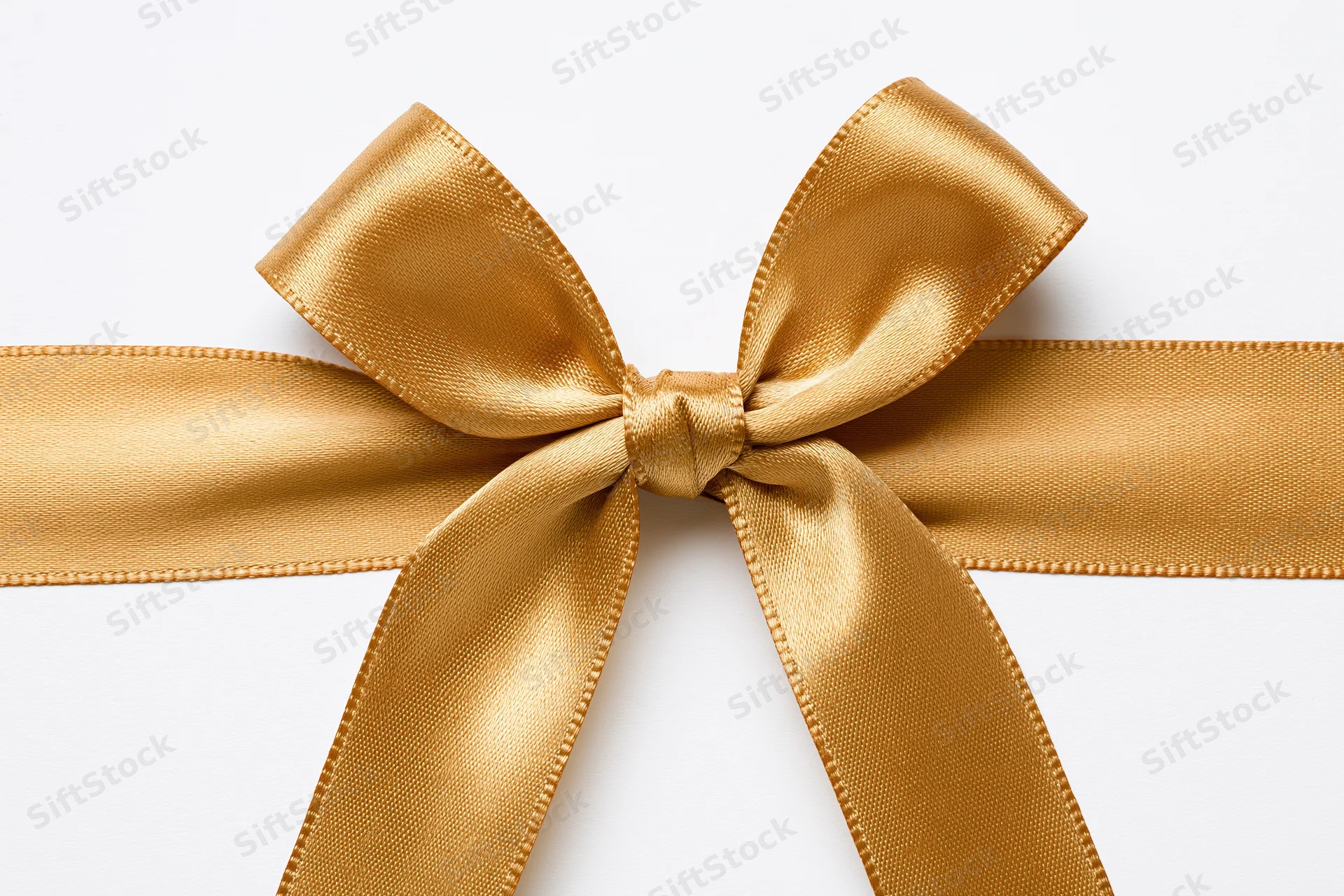Golden satin ribbon tied into a bow centered on a white background