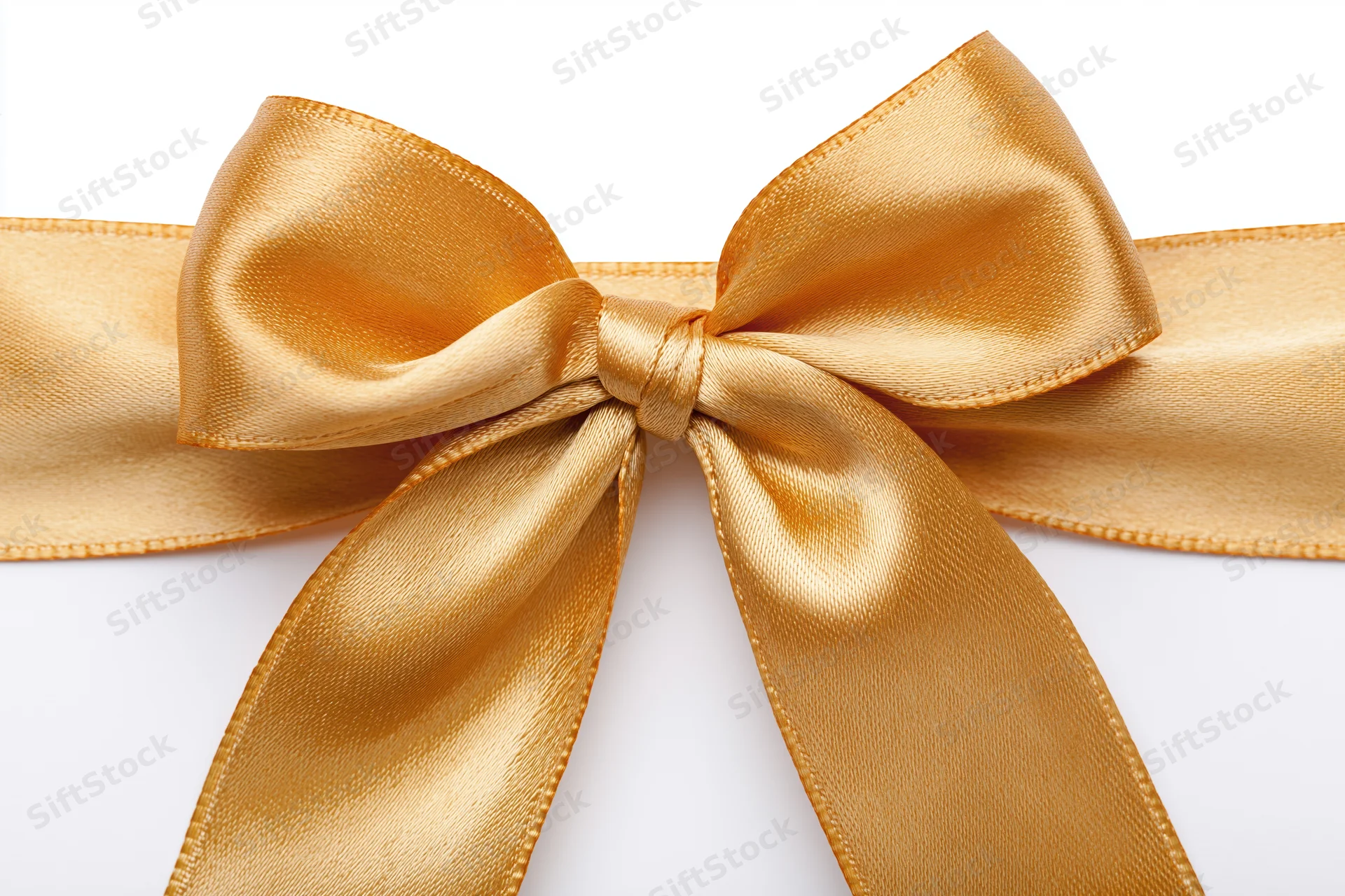 Golden satin ribbon tied into a bow centered on a white background