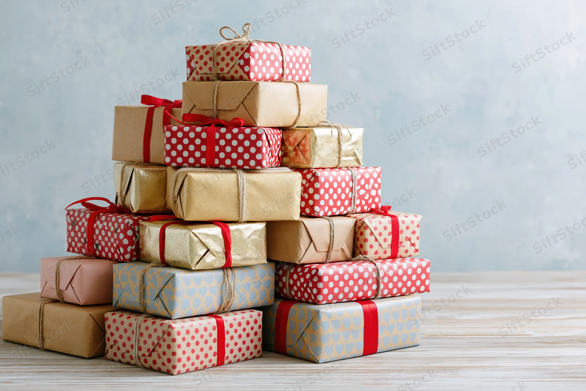 Stack of wrapped gift boxes arranged in pyramid shape on wooden table