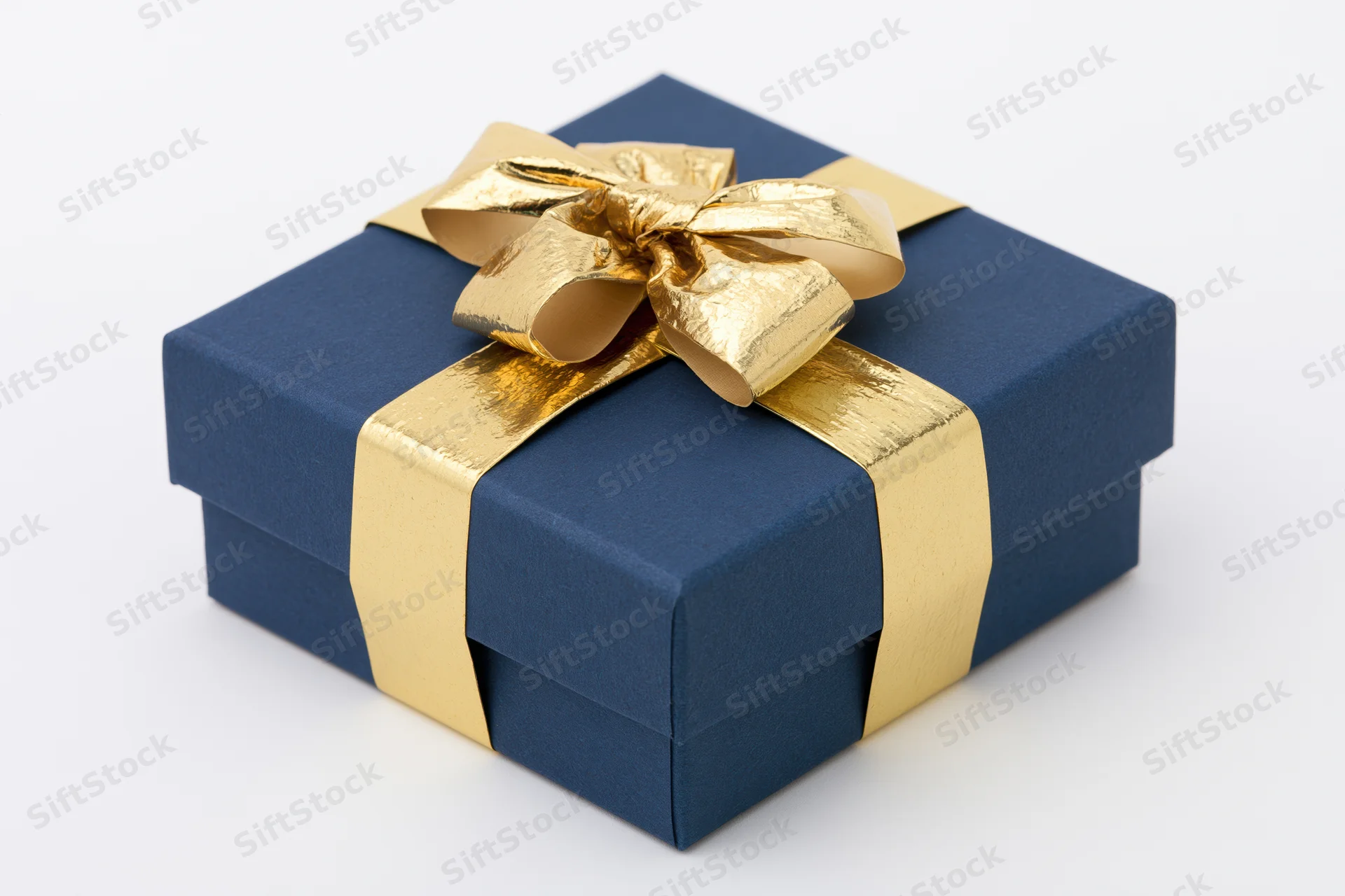 Navy blue gift box wrapped with gold metallic ribbon and bow on white background