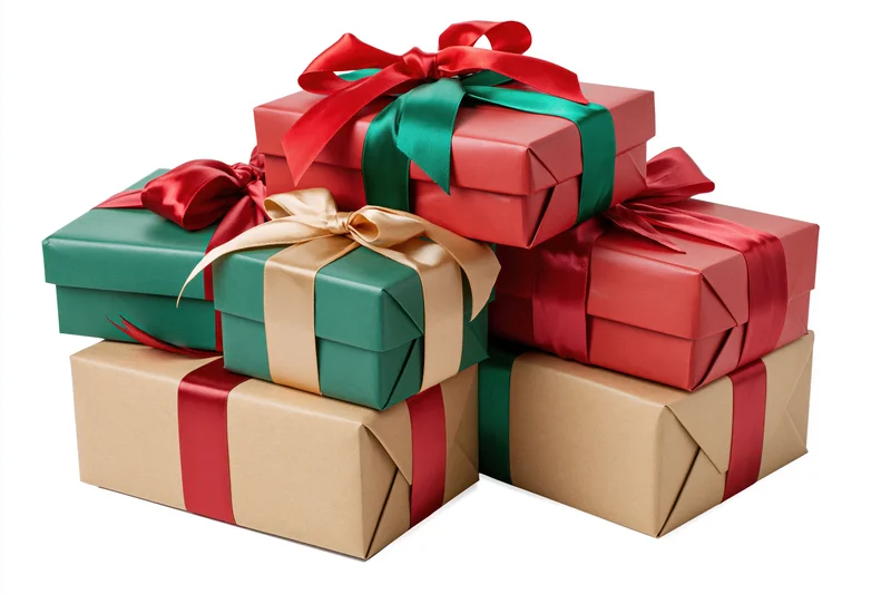 Stack of wrapped christmas gift boxes in red, green, and brown paper with ribbons and bows on white background