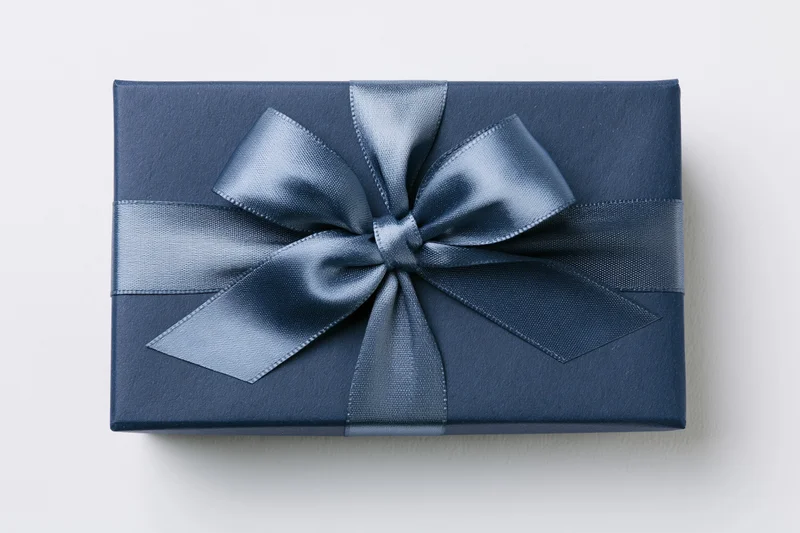 Navy gift box wrapped with satin ribbon bow on white background