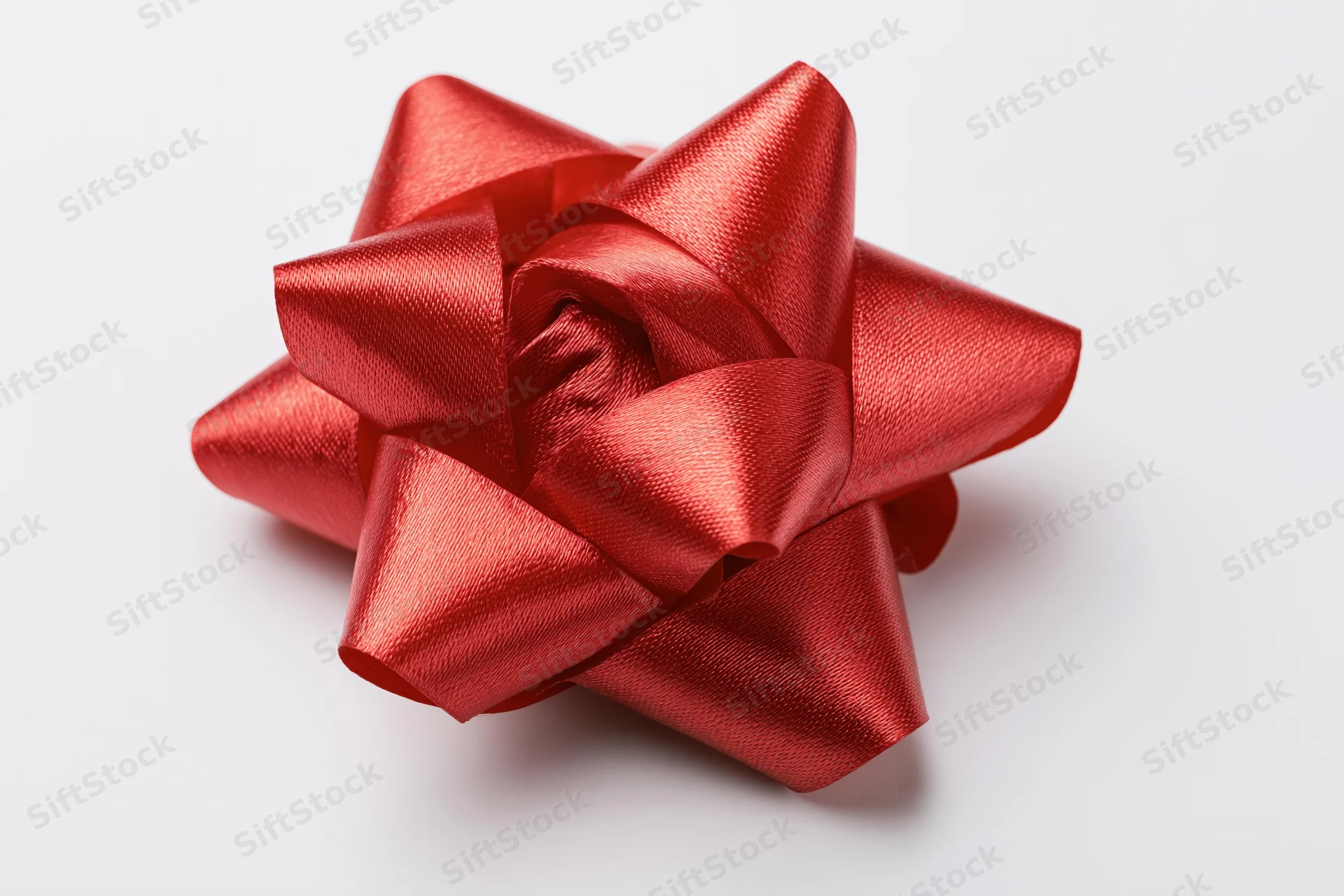Red satin gift bow on white background