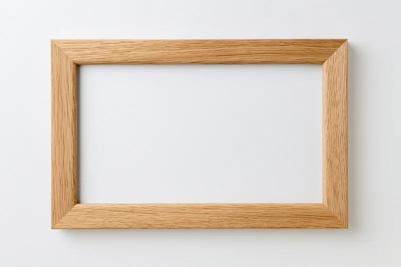Light oak wooden picture frame hanging on white wall, empty and ready for display