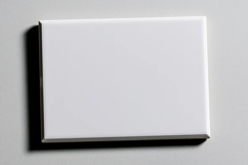 Blank white rectangular glass tile mounted on a light gray wall