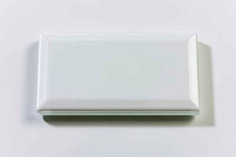 Blank white rectangular glass tile lying flat on a plain surface