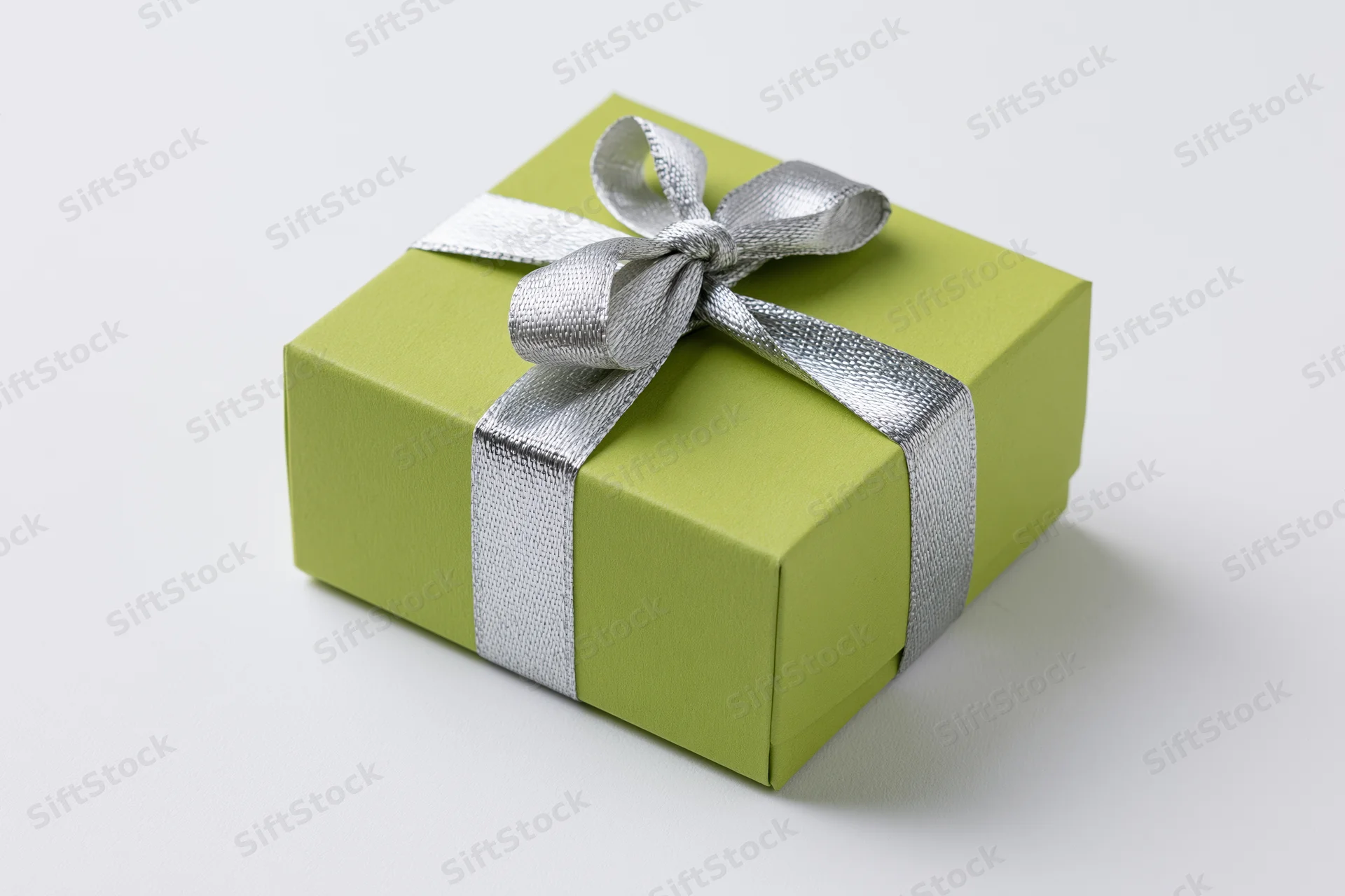 Green gift box wrapped with silver ribbon and bow on white background