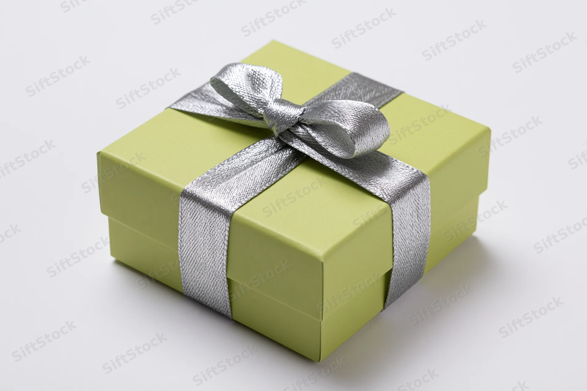 Lime green gift box with silver ribbon and bow on white background