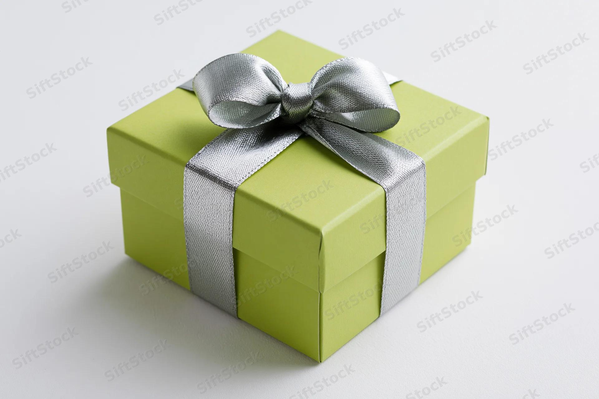 Green gift box with silver ribbon and bow on white background