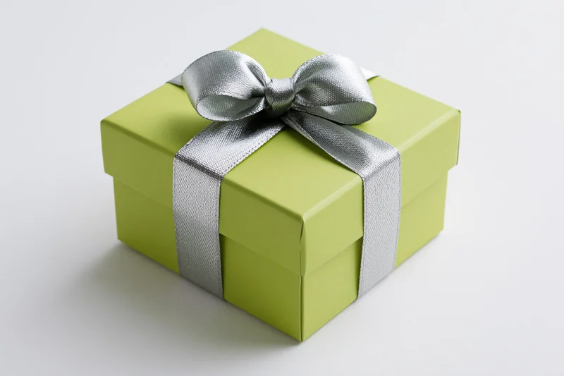 Green gift box with silver ribbon and bow on white background