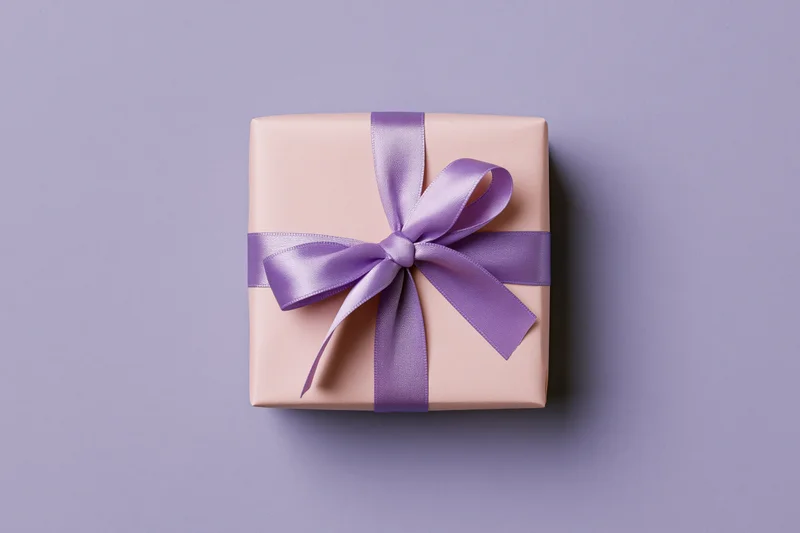 A gift box wrapped in pale pink paper with a purple satin ribbon bow on a lavender background