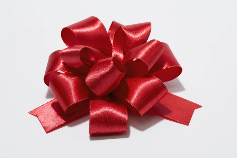 Red satin gift bow with multiple loops on white background