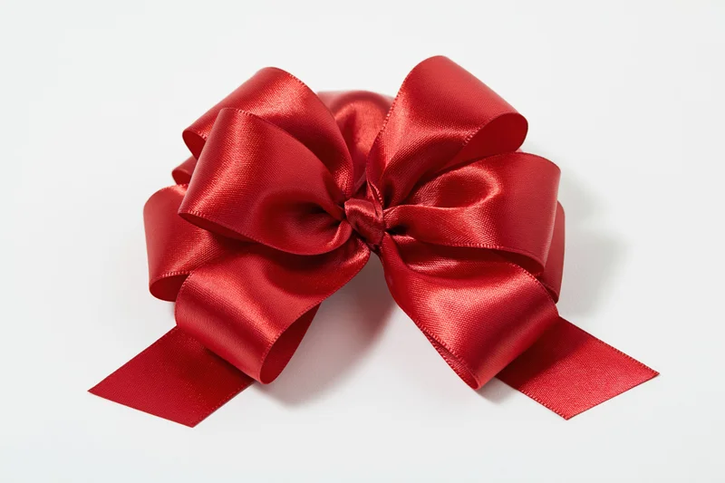Red satin gift bow with multiple loops on white background