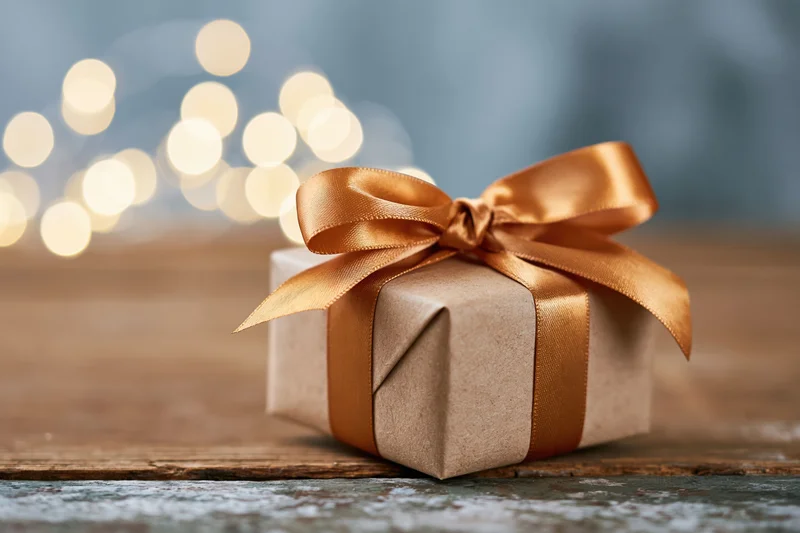 Small gift box wrapped in brown paper tied with copper ribbon