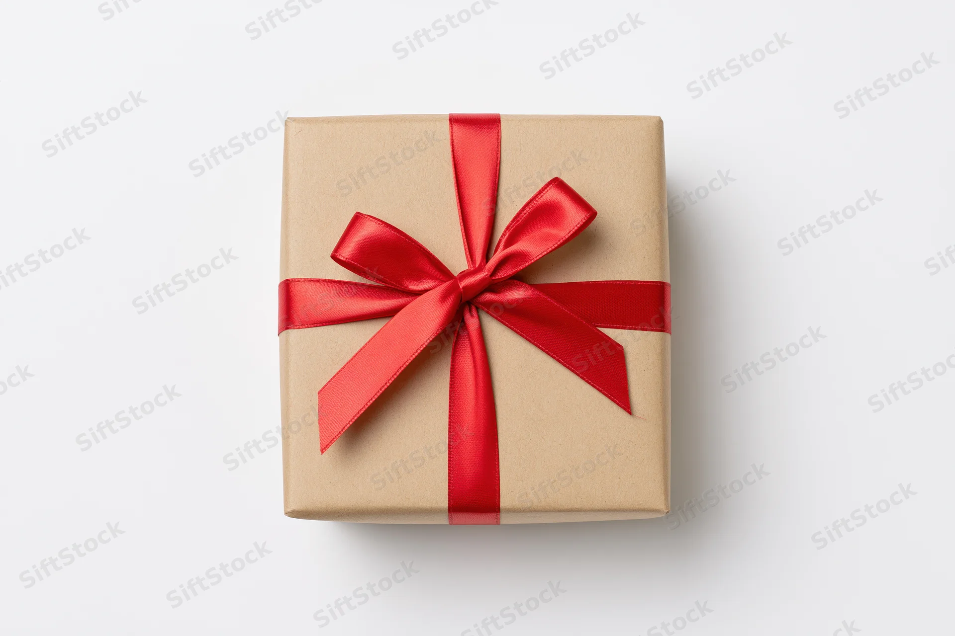 Square gift box wrapped in kraft paper with red ribbon bow on white background
