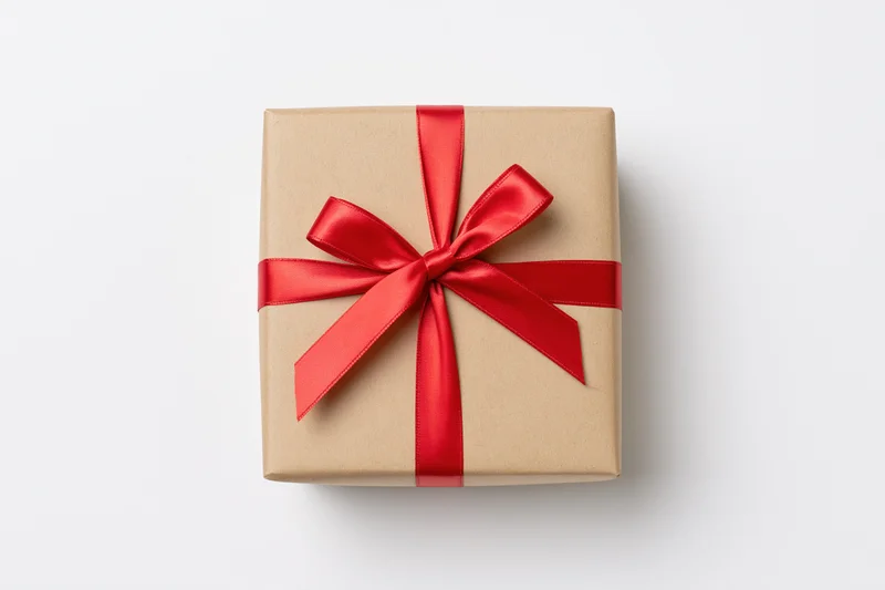 Square gift box wrapped in kraft paper with red ribbon bow on white background