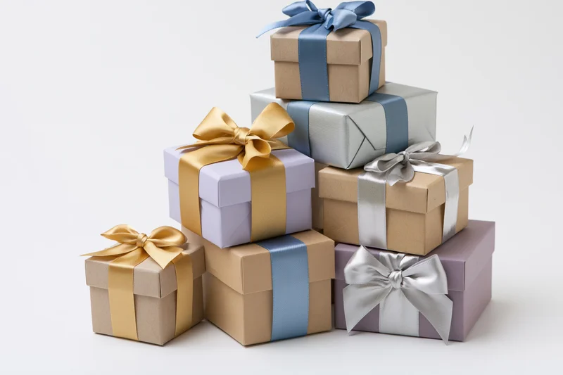 Stack of seven wrapped gift boxes arranged in a loose pyramid on white background