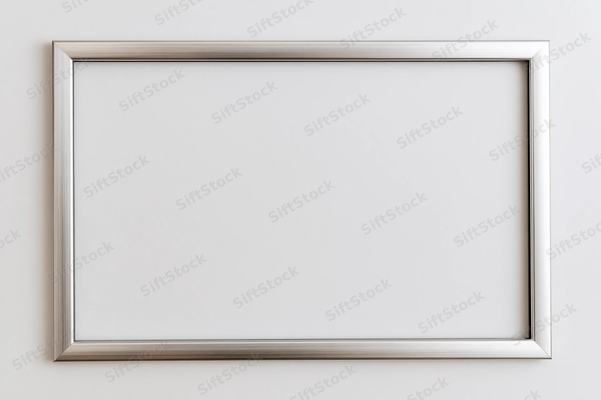 Silver metallic picture frame hanging on a white wall with blank interior