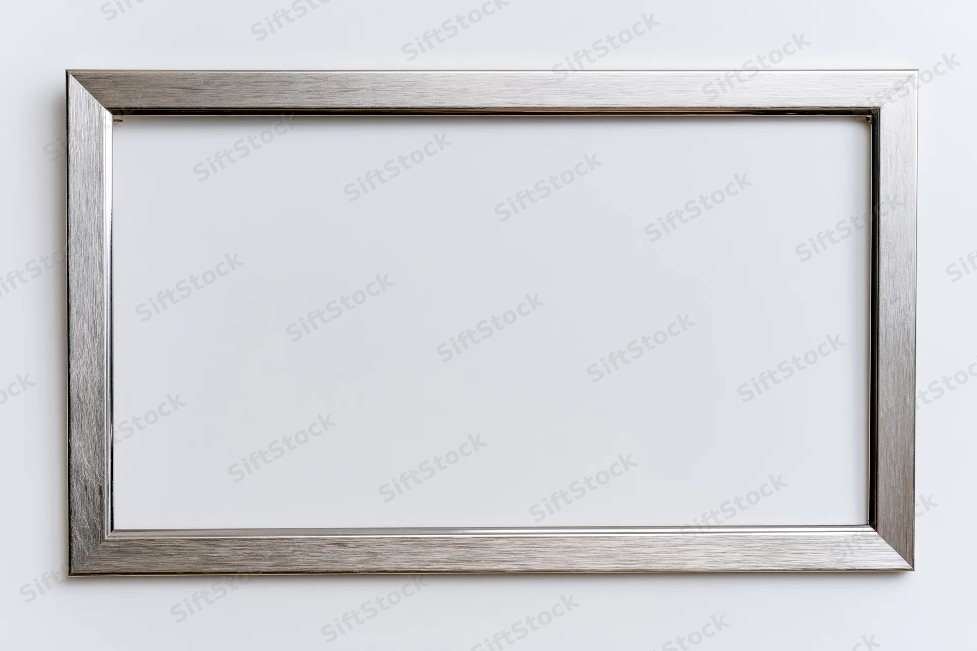 Silver metallic picture frame hanging on white wall with empty space for artwork