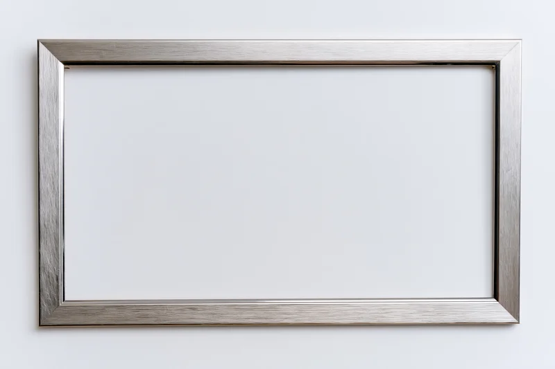 Silver metallic picture frame hanging on white wall with empty space for artwork