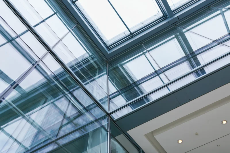 Upward view of a modern glass curtain wall in an office building interior