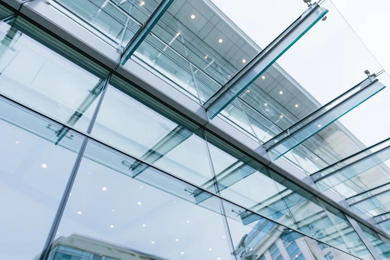 Upward view of a modern glass curtain wall on a corporate building exterior