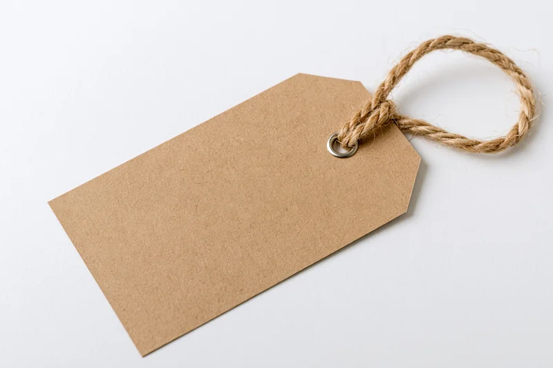 Blank kraft paper luggage tag with twisted jute twine string on white background