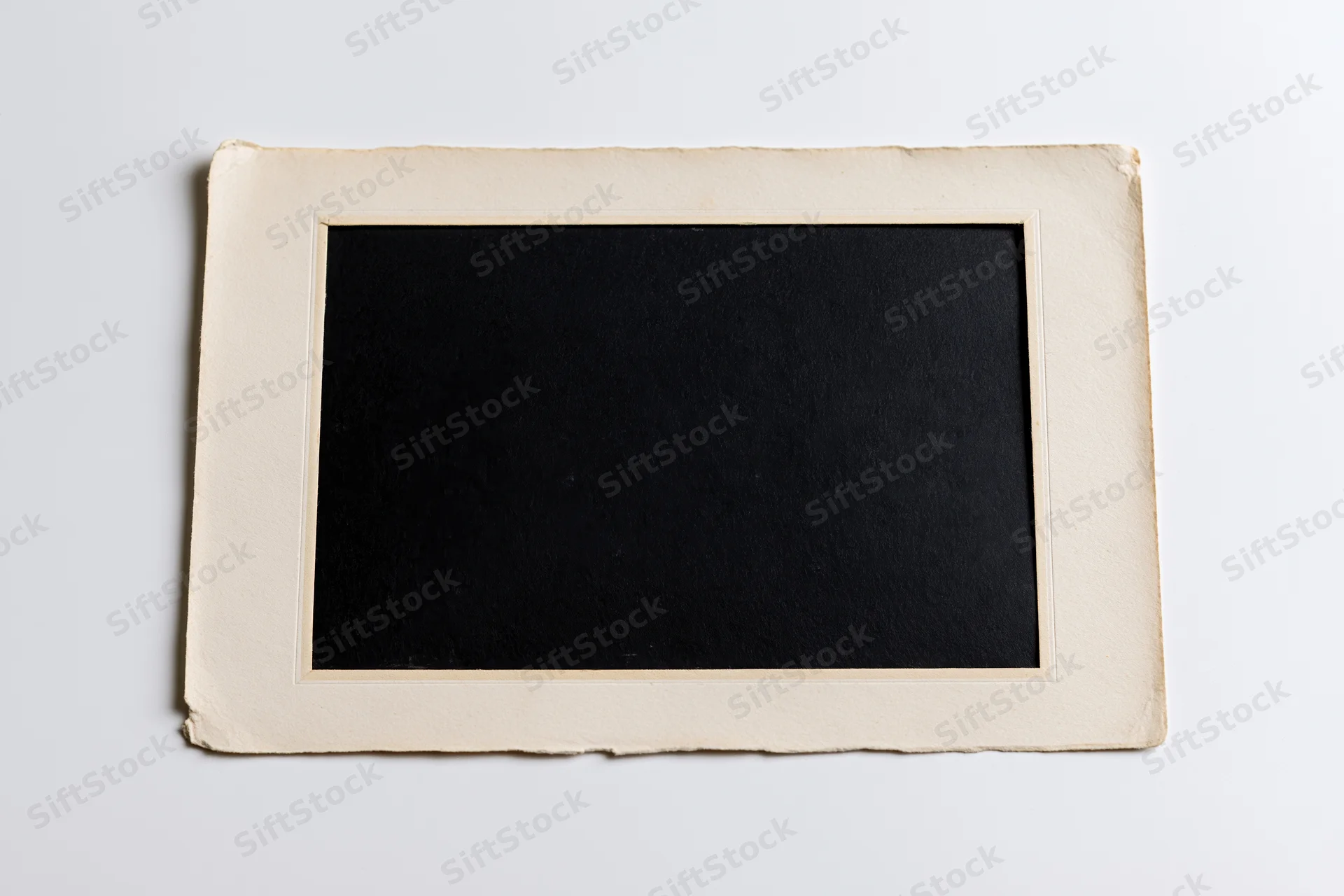 Vintage blank photo print with beige border lying flat on white surface
