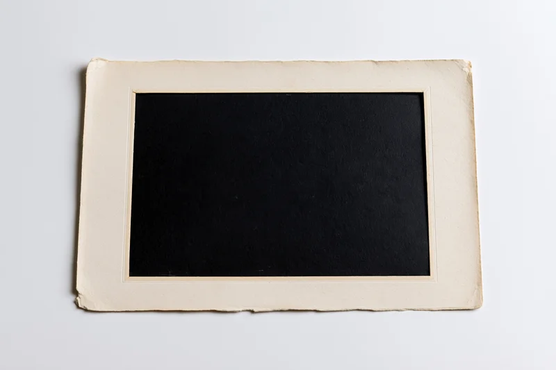 Vintage blank photo print with beige border lying flat on white surface