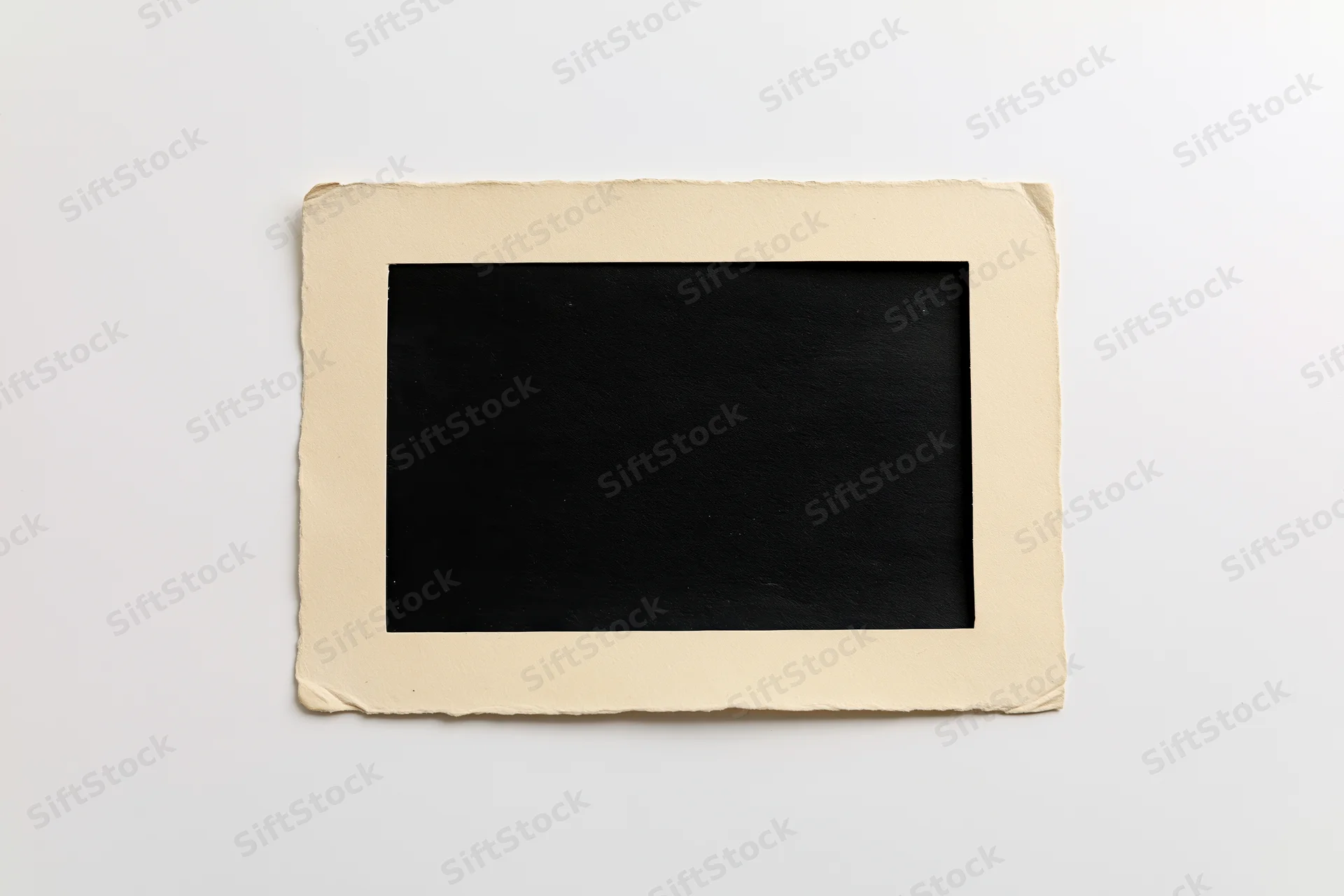 Vintage blank photo print with torn paper border lying flat on white surface