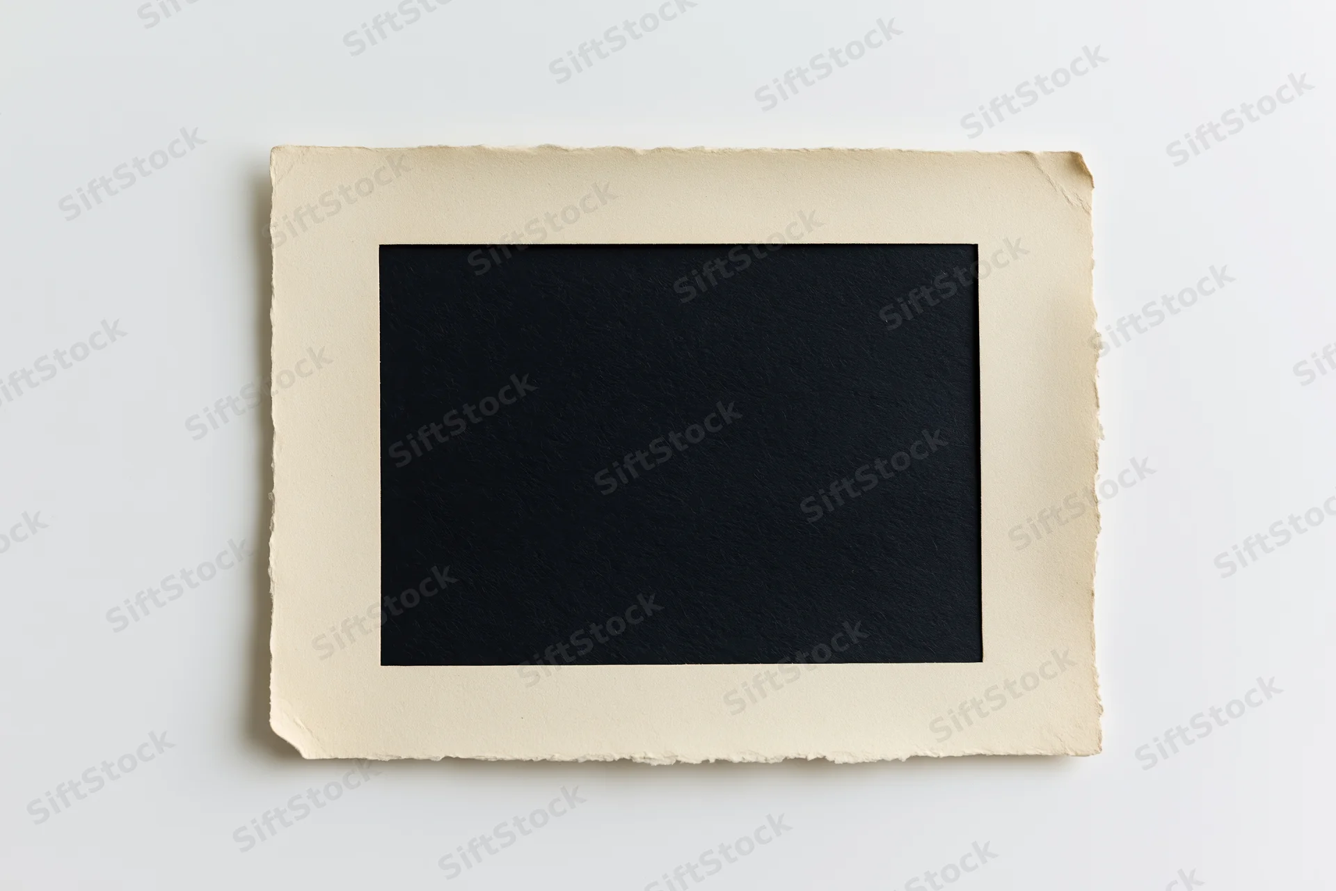 Vintage blank photo print with torn edges lying flat on white surface