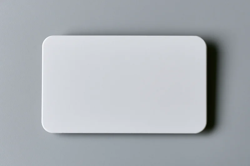 Blank white business card with rounded corners lying flat on gray surface