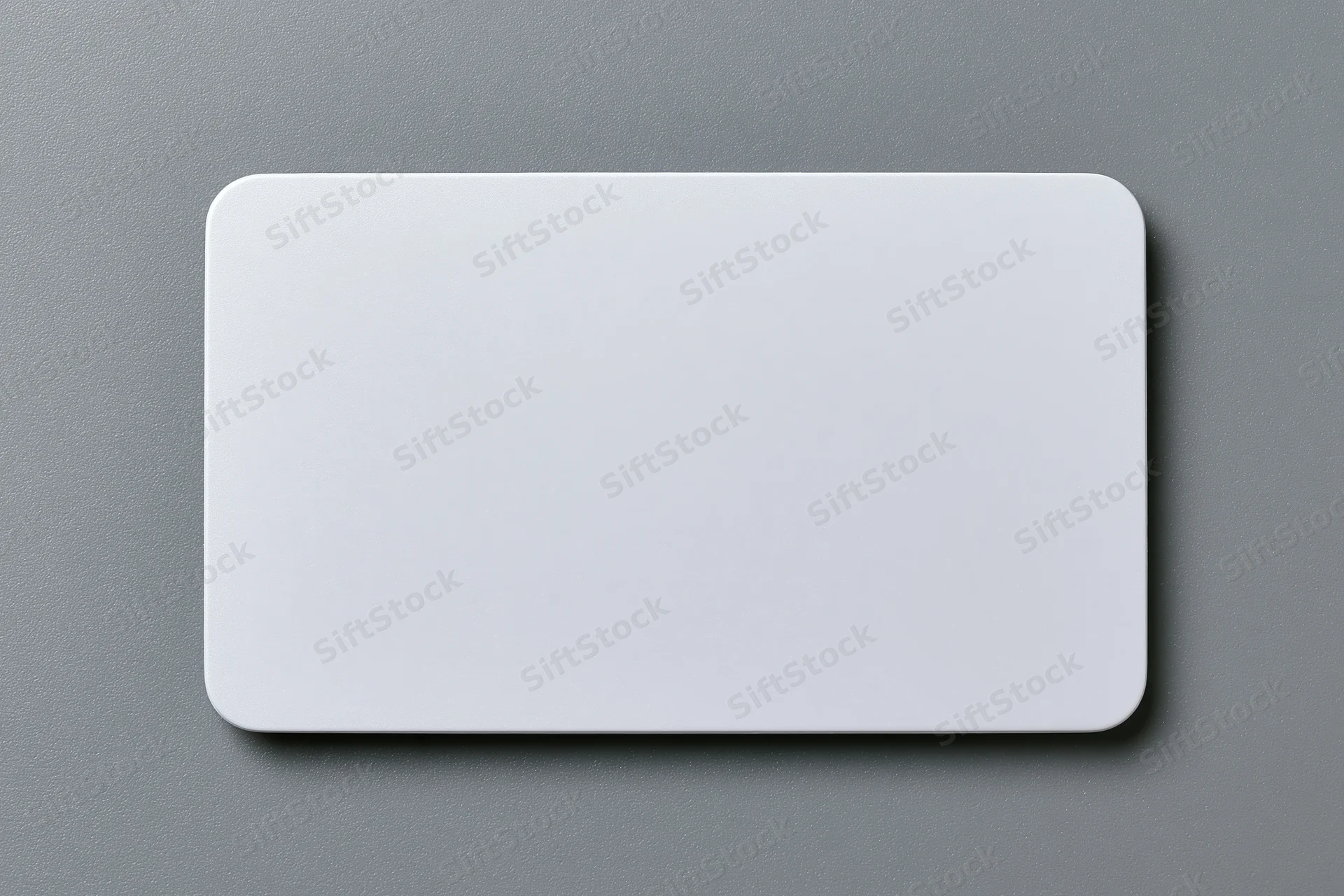 Blank white plastic card with rounded corners lying flat on gray surface