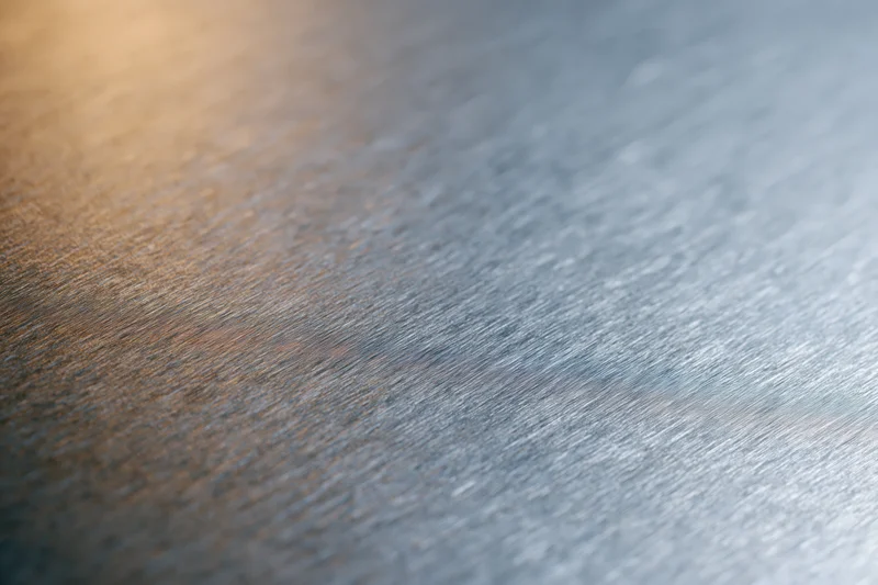 Close-up of brushed metal surface with soft reflected light gradient
