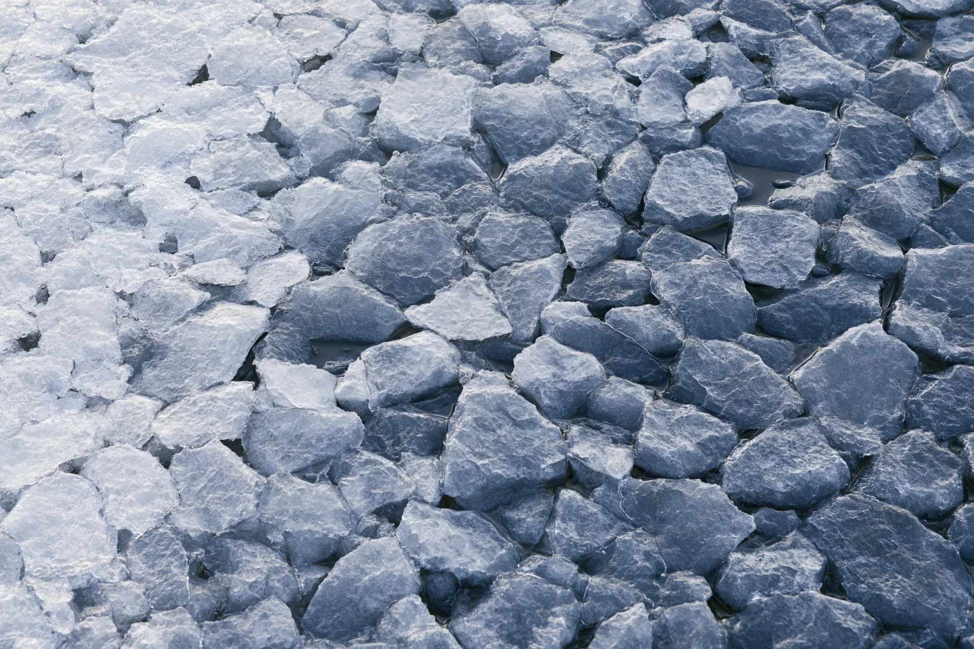 Close-up view of fractured ice surface with cracked patterns and blue-white texture