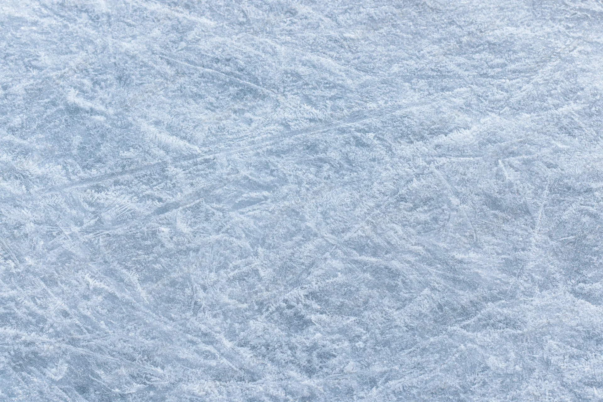 Close-up of a frozen ice surface with natural frost patterns and crystalline texture
