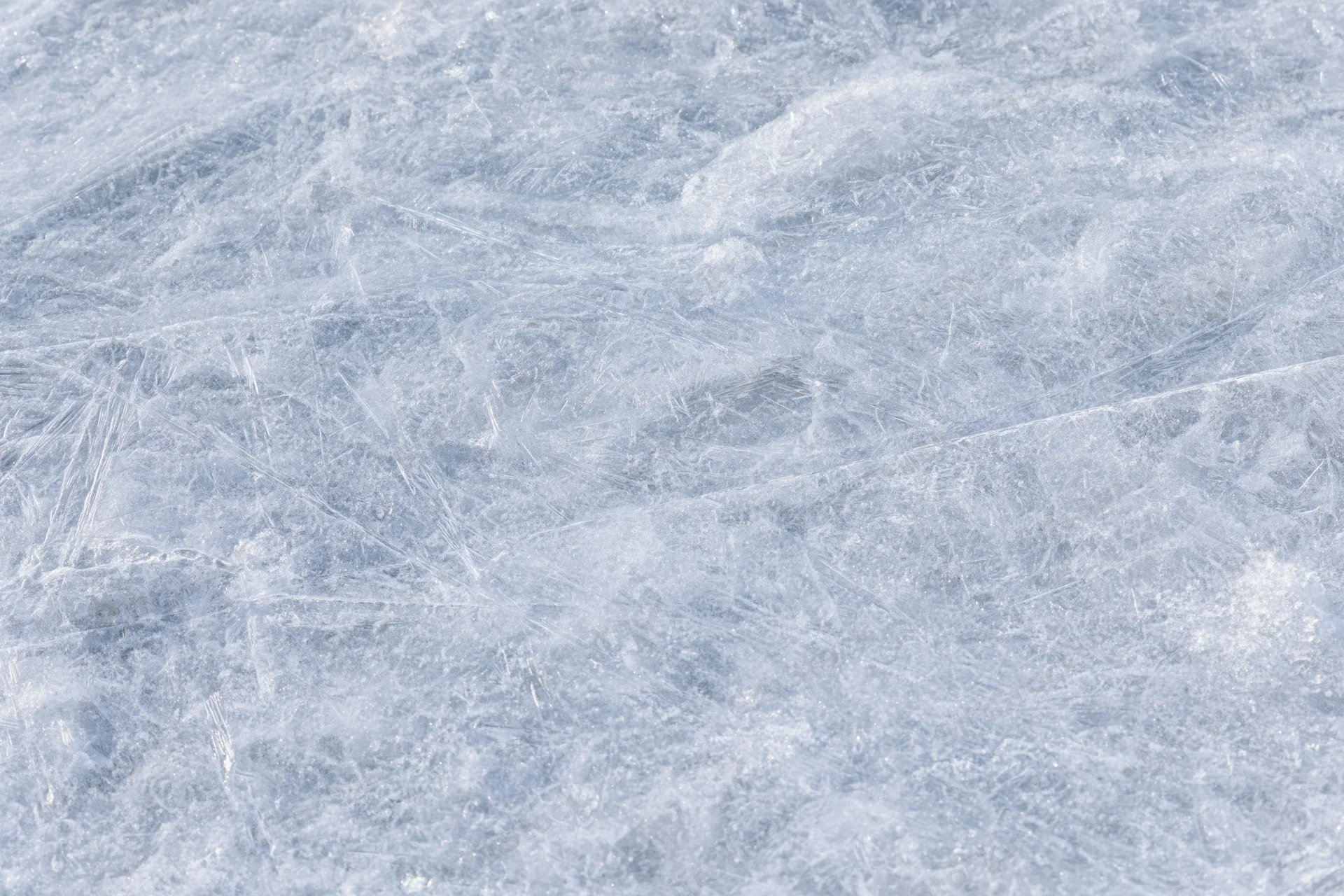 Close-up of a frozen ice surface with natural texture and scratches