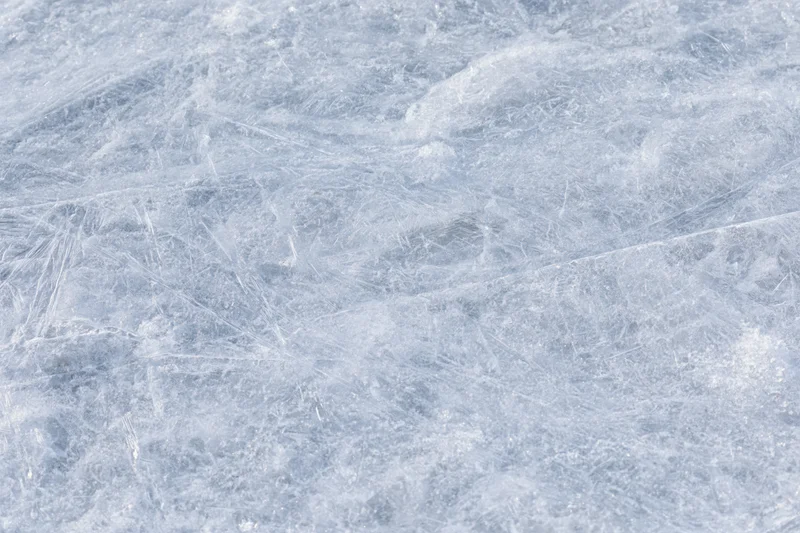 Close-up of a frozen ice surface with natural texture and scratches