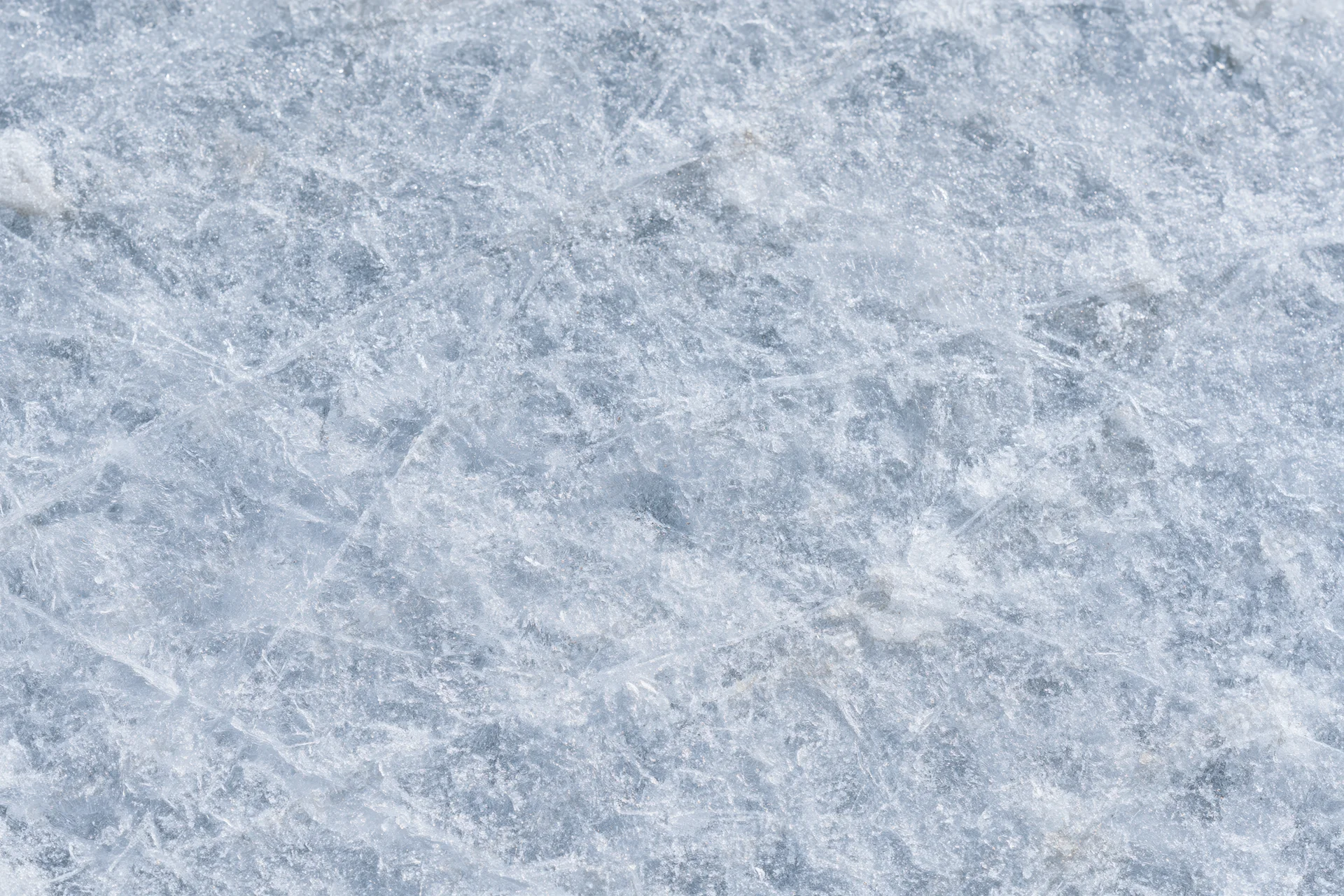 Close-up of a frozen ice surface with natural texture and frost patterns