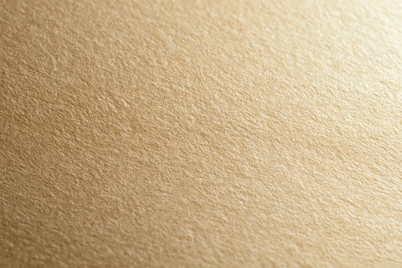 Close-up of a matte gold textured surface filling the frame
