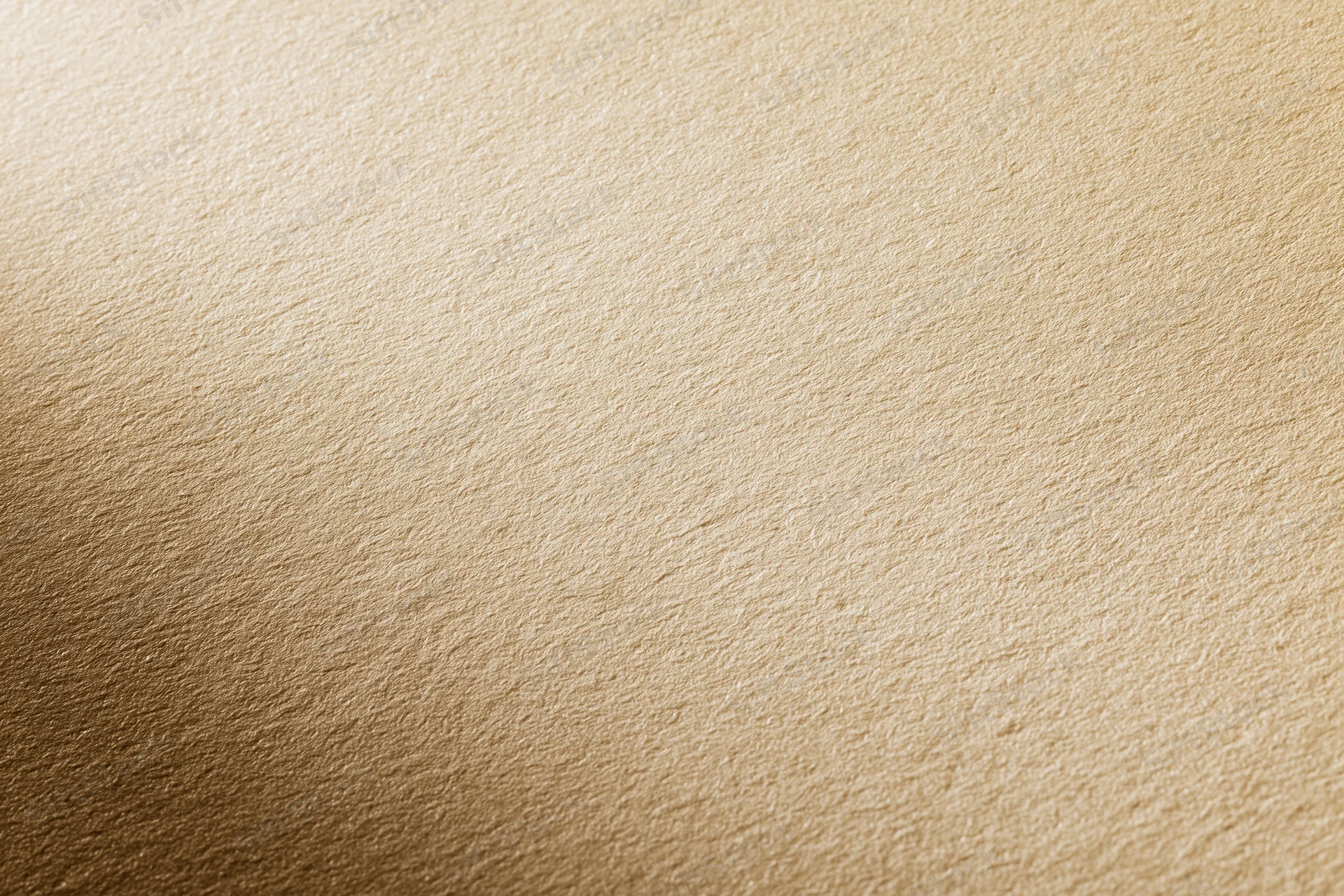 Close-up of a matte gold textured surface with soft gradient lighting