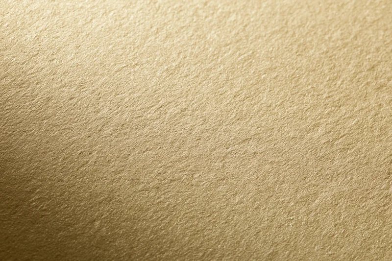 Close-up of a matte gold textured surface filling the frame